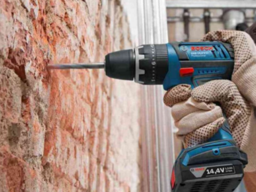 мастер сверлит стену