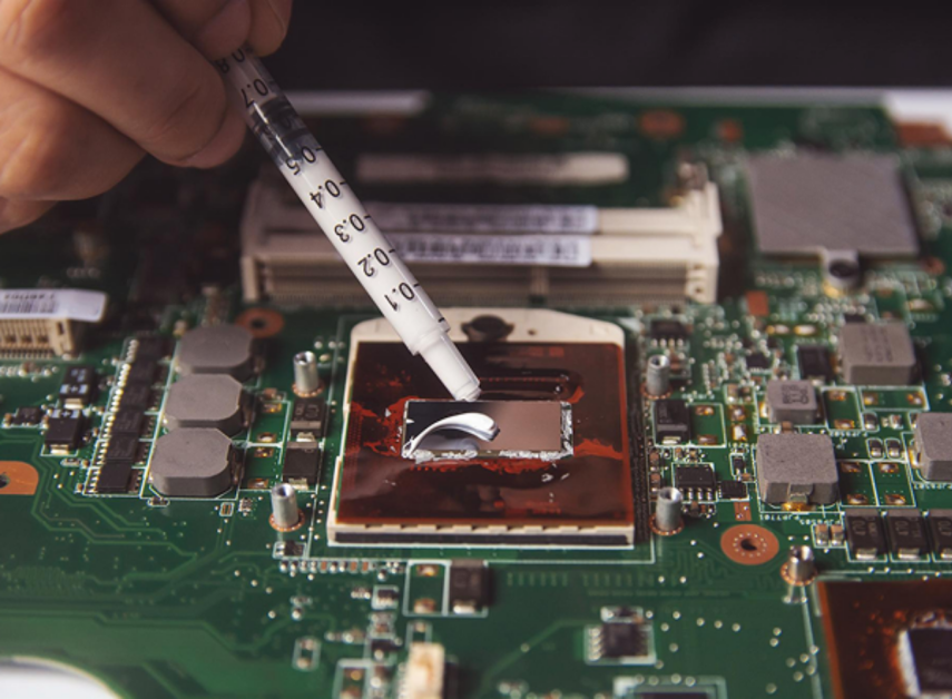 Крупный план_ рука держит тюбик с термопастой и выдавливает небольшую каплю на центр кристалла процессора